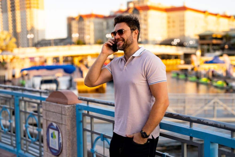 Handsome confident man talking on a cell phone on the street.
