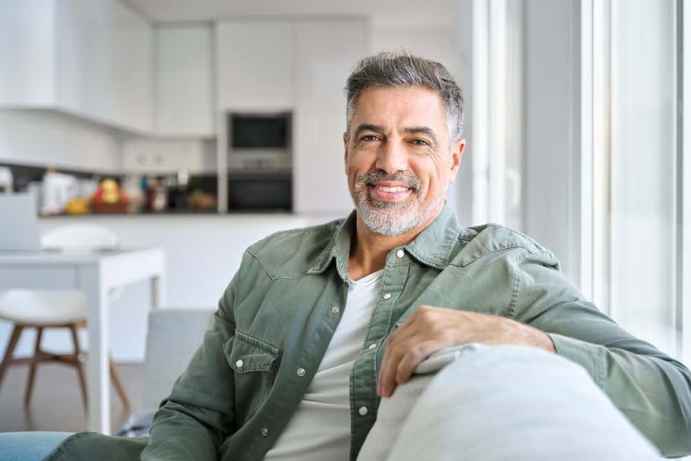 Smiling relaxed middle-aged man relaxing on a sofa