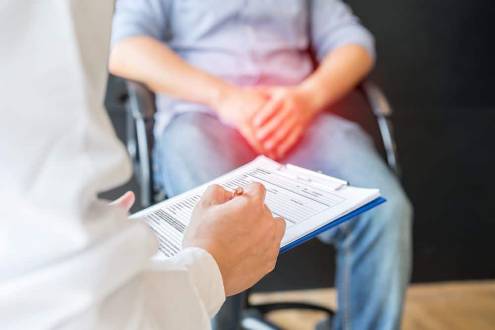 A male doctor diagnosing a man complaining about testicular pain.