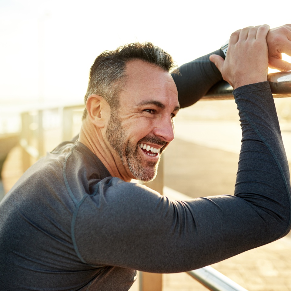 Happy, running and man in morning rest for exercise, marathon training and cardio workout in town. Sports, sunshine and person for wellness, health and recovery for performance, endurance and fitness.