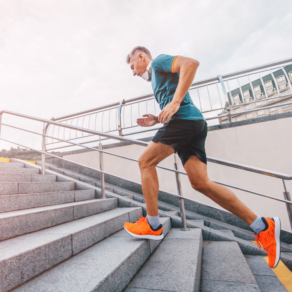 healthy lifestyle middle aged man runner running upstairs on city stairs. Motion shot.