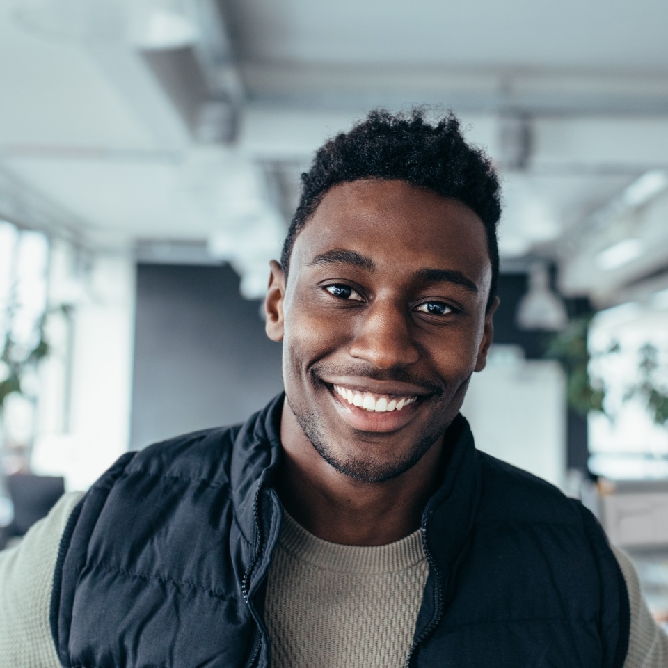 Smiling designer standing in workplace and looking at camera. Handsome young man in design office.