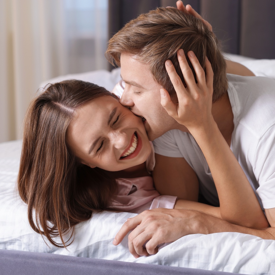 Lovely couple enjoying each other in bed at home