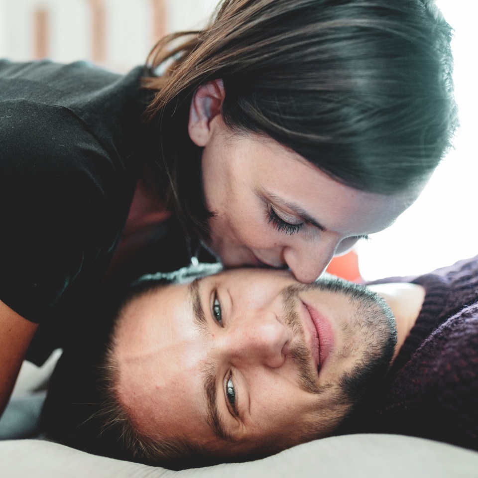 Couple sharing tender moment on cozy bed