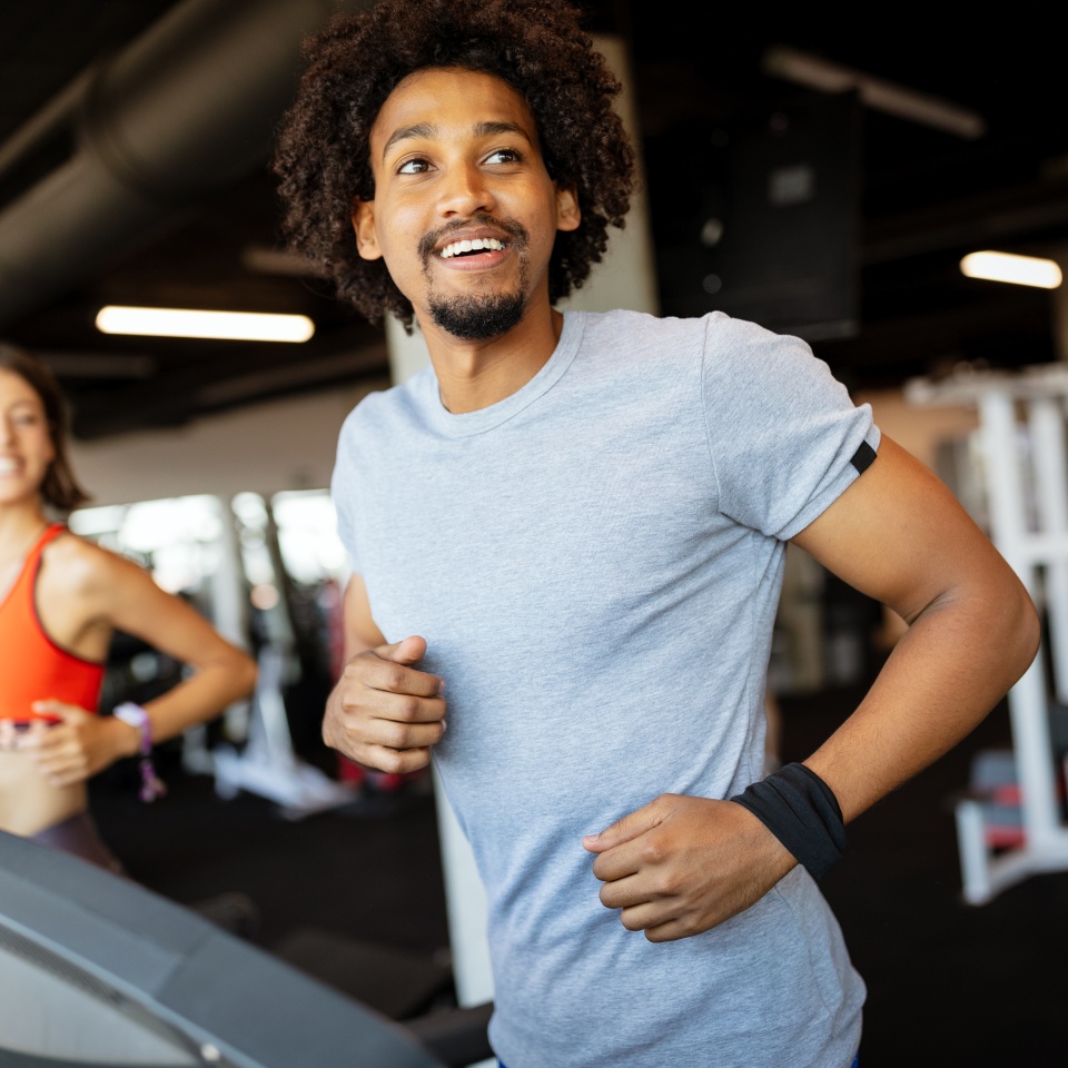 Fit group of young friends exercising on a treadmill in gym