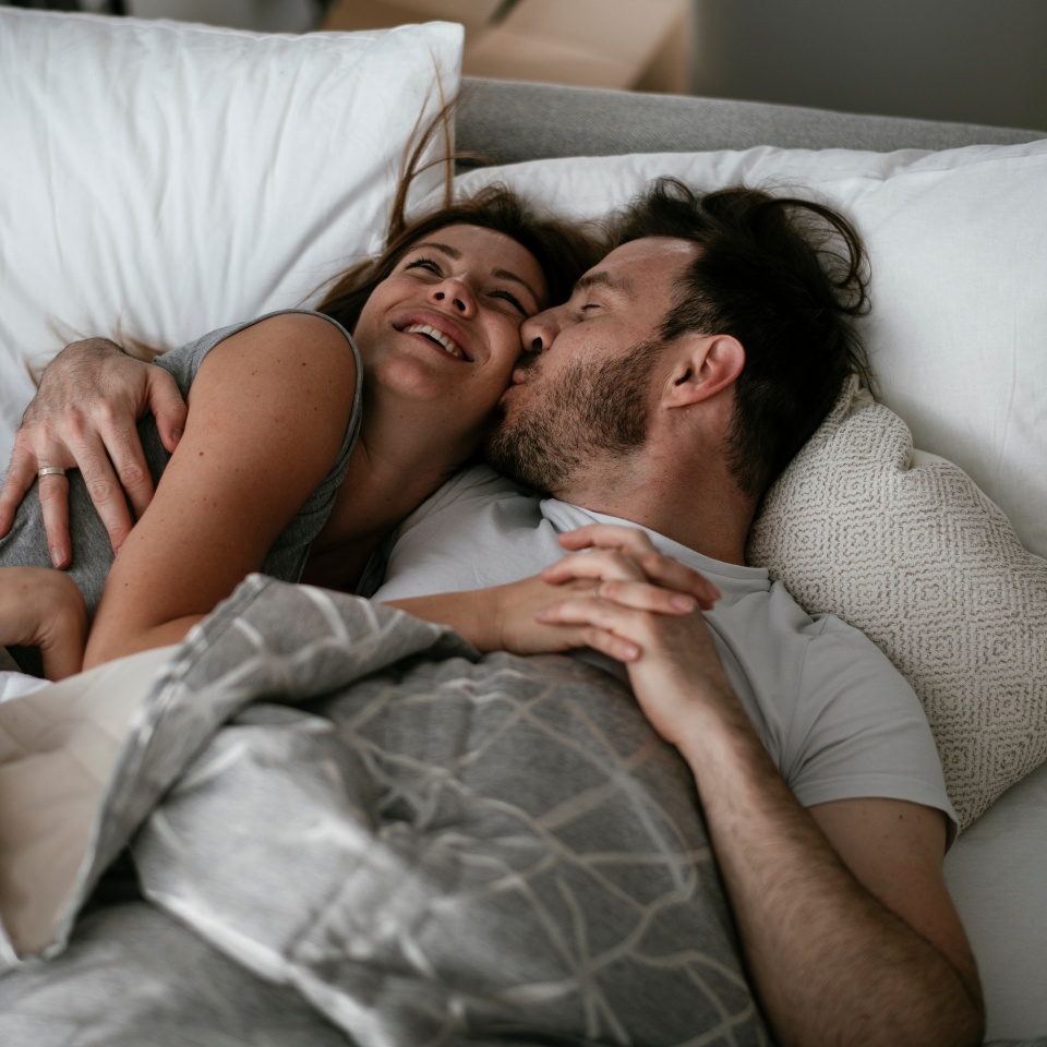 Young loving couple in bed. Happy couple relaxing in bed.