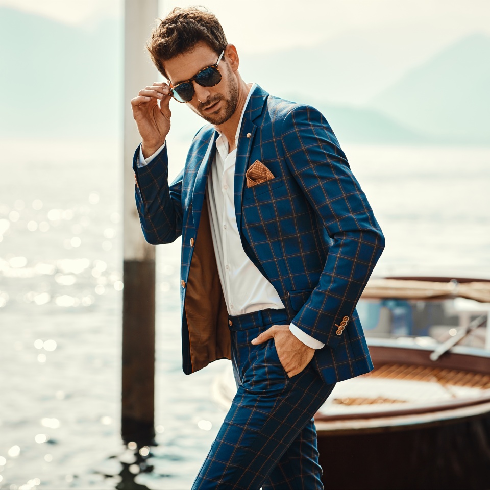 Young handsome man in classic suit wear sunglasses over the blurred lake