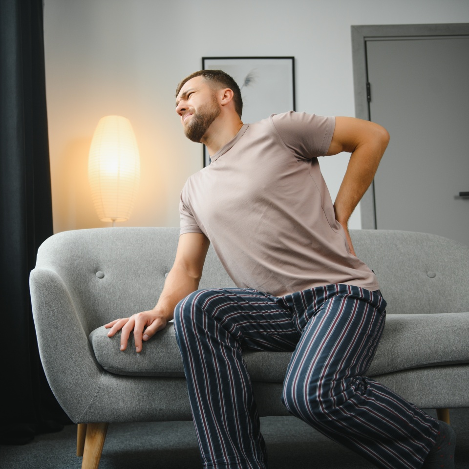 Back pain, kidney inflammation, man suffering from backache at home, health problems concept