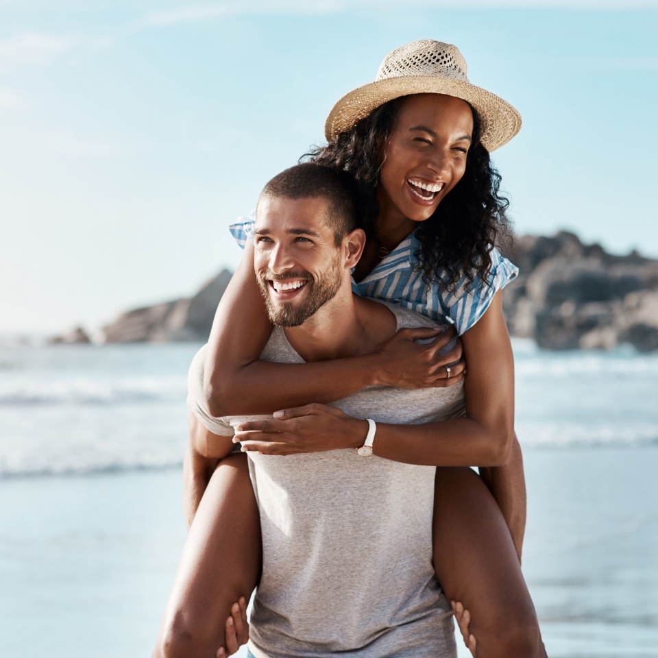 Romance, ocean and piggy back, happy couple with blue sky on romantic summer holiday travel to beach. Love, man and woman at sea, happiness on date and romantic adventure vacation together in Mexico