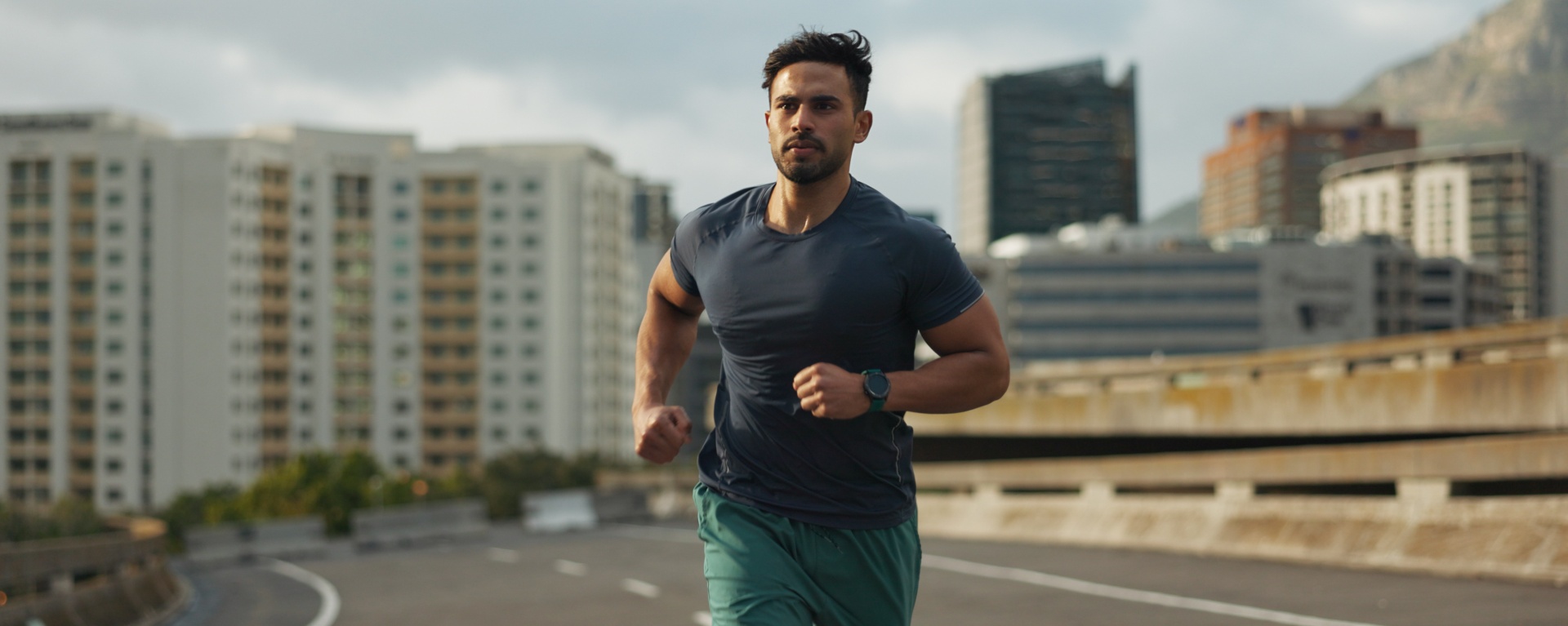 Running, city and man on road in training, endurance and fitness lifestyle for marathon competition. Indian runner, exercise commitment and body wellness for cape town race, progress and urban sport.